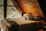 Our loft bedroom with custom curtains on the wall of windows and queen bed.