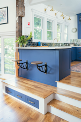 Kitchen, Concrete Counter, Colorful Cabinet, Wall Lighting, Undermount Sink, Medium Hardwood Floor, and Mirror Backsplashe Kitchen Peninsula and Built-ins  Photo 6 of 24 in Cambridge Townhouse by SKA