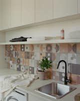 A playful, naturally-toned backsplash tile adds charm to the laundry room.  Photo 10 of 18 in Curves and a Courtyard Transport This Australian Weatherboard Cottage From Its Suburban Setting