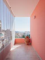 This brightly colored balcony can make any day cheery, while providing filtered sunlight through the chain-link screen.  Photo 12 of 13 in You’ll Either Love or Hate This Renovated Lisbon Flat’s Wooden Cabinet Pulls