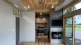 Kitchen, Concrete Counter, Refrigerator, Wood Cabinet, Drop In Sink, Subway Tile Backsplashe, Medium Hardwood Floor, and Recessed Lighting  Photo 2 of 7 in Modern Shipping Container House by Andrea Nentwick
