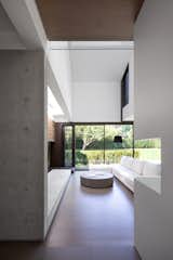 Opening view: Front entrance reveals a light-filled living room in poured concrete and engineered hardwood floors.