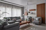 The living area aesthetic is due to its bare minimal theme and enchanting voids within the furniture pieces. The bespoke customized metal shelf accompanied by a wooden trunk is part of the design to inculcate the souvenirs around the world. 