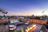 The large rooftop deck features a firepit and wraparound bench as well as an adjacent lounge.