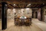 An old and neglected storage area was restored and converted into a dining room. The stone walls, the old doors, and the wooden structural elements were kept.