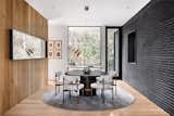 The wood clad wall balances the charcoal brick interior/exterior wall.  A mooi light fixture delicately hangs over clients existing table with custom rug and dining chairs.  The steel framed mirror hanging was designed by McCarty.