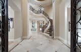 A double-height foyer with floating circular staircase acts as an appropriately elegant center to the home, giving the estate a palatial feel whilst maintaining a welcoming atmosphere