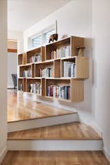 Custom built book shelves create a library out of the hall.  Steps down into the primary suite encourage a transition from work to rest.