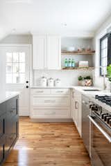 A perfect mix of materials: knotty pine floors, Carrara marble backsplash, quartz counters and dark grey painted island cabinetry complete the modern farmhouse look.  Photo 5 of 6 in Kitchen from Favorites