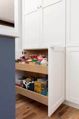 Maximizing kitchen storage with pull out drawers and a full pantry wall of storage.