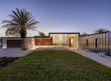 Exterior, Metal Roof Material, Stone Siding Material, Metal Siding Material, Wood Siding Material, House Building Type, Hipped RoofLine, Flat RoofLine, and Stucco Siding Material Evening View from the Street  Photo 5 of 16 in Lear Residence by Lear Studio Architects