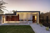 Exterior, Metal Siding Material, Hipped RoofLine, Metal Roof Material, Stucco Siding Material, Wood Siding Material, Flat RoofLine, Stone Siding Material, and House Building Type Evening View from the Street  Photo 6 of 16 in Lear Residence by Lear Studio Architects