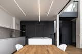 Kitchen, Cooktops, Pendant Lighting, Medium Hardwood Floor, White Cabinet, Undermount Sink, Track Lighting, and Ceiling Lighting  Photo 5 of 26 in Loft Apartment With Black Box by Komon Architekti