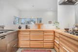 Kitchen, Wood Counter, Range Hood, Dishwasher, Ceiling Lighting, Cooktops, Wood Cabinet, Concrete Floor, and Metal Backsplashe Kitchen  Photo 3 of 3 in A Japanese Designed Modern Home Asks $759K CAN near Canada's Capital by Kevin Saunders