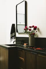 The walnut cabinets and black granite counters continue in the hall bathroom. 