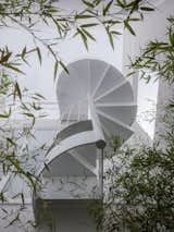 Staircase, Metal Railing, and Metal Tread View from the terrace on the first floor. A
helicoidal stair fly over the terrace and connects the
second floor with the solarium on the rooftop  Photo 7 of 9 in Galgo House by M&E Clara Murado y Juan Elvira