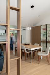 Architectural wooden custom partition at the entry creates visual connection while maintaining spatial separation with the dining, living room and the kitchen. 