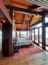 Bedroom, Medium Hardwood Floor, Bed, Accent Lighting, Night Stands, and Pendant Lighting Bedroom timber frame addition with views of Colvos Passage  Search “corvo” from Vashon Island timber frame addition