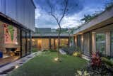 Outdoor, Garden, Lap Pools, Tubs, Shower, Wood Patio, Porch, Deck, Grass, Flowers, Trees, Gardens, Large Patio, Porch, Deck, Concrete Fences, Wall, and Landscape Lighting courtyard at dusk  Photo 17 of 22 in Courtyard House for Two Boys by Leo Shieh