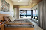 Master Bedroom on the Second Level with Ocean Views: Warm earth colors and textures create a serene bedroom environment.