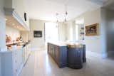 Kitchen, Quartzite Counter, Pendant Lighting, Cooktops, Wood Cabinet, White Cabinet, Range, Accent Lighting, Ceramic Tile Floor, Wine Cooler, and Drop In Sink Kitchen   Photo 3 of 10 in Modern artist reinvents classic Loire-Valley château by Carsten Sprotte