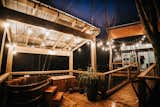 Outdoor, Trees, Metal Fences, Wall, Hot Tub Pools, Tubs, Shower, Large Patio, Porch, Deck, Wood Patio, Porch, Deck, Hanging Lighting, and Back Yard Soaking Tub and home at night  Photo 12 of 13 in A Modern Treehouse by Emily Bigham Unkle | Emily Unkle Studio