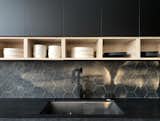 The dark cabinets in the kitchen are accented by lighter, open shelving.