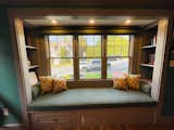 The reading nook my husband built. Featuring custom pillows with fabric we chose at our local store we buy most of our paint, and wallpaper. 
