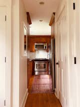 Kitchen, Stone Counter, Recessed Lighting, Wood Cabinet, Dishwasher, Range, Accent Lighting, Medium Hardwood Floor, Refrigerator, Microwave, Subway Tile Backsplashe, and Undermount Sink Galley  Photo 9 of 10 in Little House on the River by LHOR