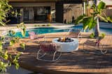 White stucco fire pit on sustainable Moso bamboo decking with classic Brown Jordan rockers in custom lilac color straps. 