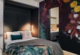 A full-height photo-mural conceals the central Murphy bed and wraps around the bathroom, turning the only interior wall into a work of art.