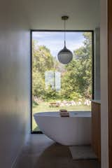 Bath Room, Ceiling Lighting, Stone Tile Wall, Freestanding Tub, and Concrete Floor Bathroom  Photo 9 of 18 in Minnedosa House by design-built