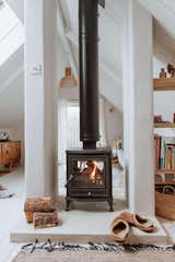 The woodburner divides the living space into two distinct zones, with a cast concrete hearth