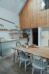 A double height space kitchen, with cladding to the upstairs bedroom reclaimed from the original timber joists