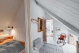 The upstairs bedroom has a curtained bed nook and shuttered windows that overlook the courtyard and kitchen