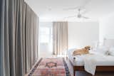 Primary Bedroom.  Continuous concealed curtain track around entire room.  Curtain also hides a TV.  Photo 9 of 19 in Doman Residence by Julie D