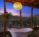 A closer look at the vista from the tub. Lightweight rope pendant light above lets the wind through easily and casts beautiful shadows at night. We also have many globe moroccan solar lanterns peppered around at night as well as lights illuminating the circle of five trees in the enclosed portion of the yard. 