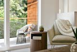 Large glass windows enable natural light flooding the reading nook in living room.
