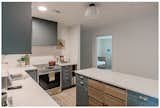 Two-toned wood and teal custom kitchen cabinets