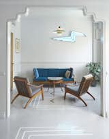 Living Room, Chair, Coffee Tables, Concrete Floor, Sofa, and Wall Lighting An Art Deco-inspired archway connects the larger arm of the L-shaped gallery to the smaller coffee area. The custom-made 'Blue Flash' neon provides a focal point.   Photo 1 of 19 in Moon Station Athens gallery and event space by Olympia Zographos