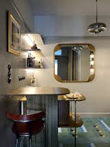 The kitchen is separated from the hallway by a bespoke brass and plywood bar and island. The custom-designed oversized 'Future' mirror opens up the relatively small kitchen and reflects light from the interior window, which was added to lighten the hallway.