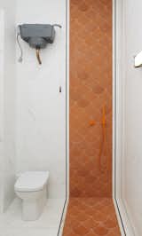 In the second bathroom, which was added to accommodate people during an event, the cement mermaid tiles run along the floor and up the wall to enlarge the space.