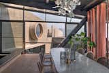 The dining room showcases a 10-foot-long terrazzo table, infused with recycled glass bits which were cast entirely on-site. The pivoting fins connect the user to the lower level of the house. 