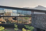The metal structure floats above the natural terrain of the ground allowing for rainwater to flow under it uninterrupted.