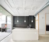 Kitchen, Ceramic Tile Backsplashe, Concrete Floor, Colorful Cabinet, Cooktops, Wall Oven, Microwave, Tile Counter, Refrigerator, Pendant Lighting, Drop In Sink, and White Cabinet Kitchen  Photo 1 of 22 in 100JOA - Row house in Mataró by Vallribera Arquitectes