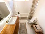Bath Room, Wood Counter, Porcelain Tile Floor, Vessel Sink, Full Shower, Soaking Tub, Subway Tile Wall, One Piece Toilet, and Accent Lighting the bathroom with custom-made vanity and soaking tub  Photo 6 of 6 in Flatrock House by Kelli Hix