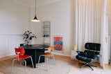 Several of Nick's vintage acquisitions appear in the dining room, from the vintage Egon Eiermann chairs around the table that he painstakingly restored to the medical supply shelves installed on the walls. His partner Nils found the pendant lamp on the street, while the artwork is by the late German printmaker Helmut Sundhaussen.