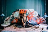 Kim in her guest bedroom, on a daybed she fashioned out of a queen-sized bed and a plywood headboard she painted. The walls are cloaked in Farrow & Ball Inchyra Blue.