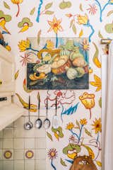 Another shot of the kitchen, where a flea market painting has been covered by the repeating floral motif of the walls. 