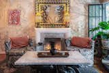 A mirror by artist Miguel Rangel hangs over a faux fireplace Kim made with a plaster and plywood frame that she later tiled over.  The chairs are vintage and the coffee table is cobbled together from two antique panther end tables finished off with a marble top.